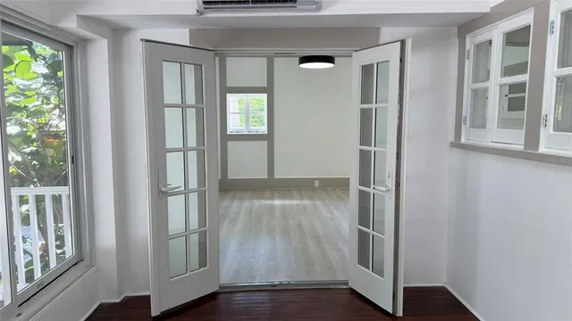 an entryway with wooden floor and windows
