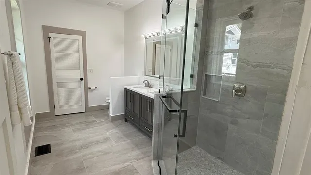 a spacious bathroom with a mirror a shower and vanity