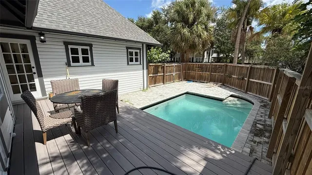 a view of a patio with table and chairs with wooden floor and fence