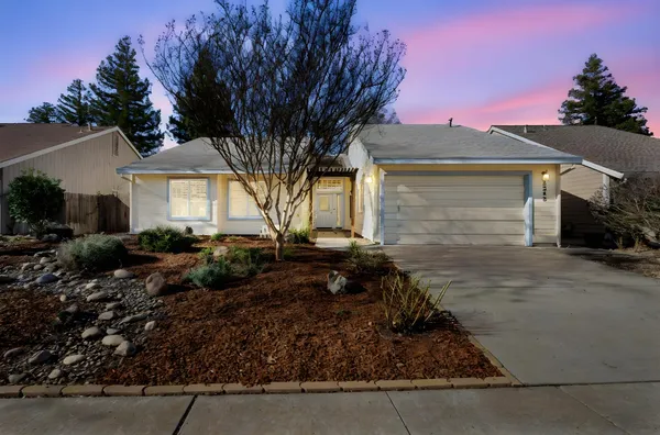 a front view of house with yard and trees around