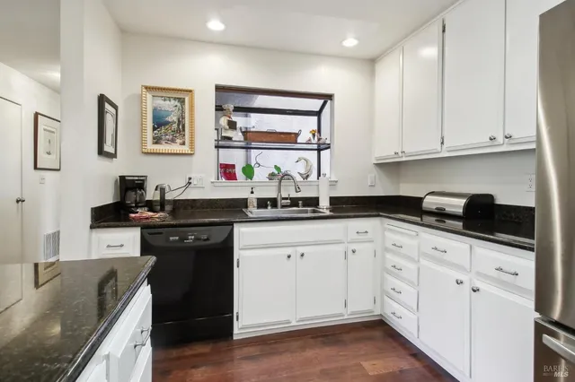 a kitchen with granite countertop white cabinets and white appliances