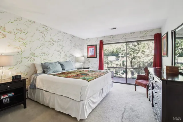 a bedroom with a bed and large windows