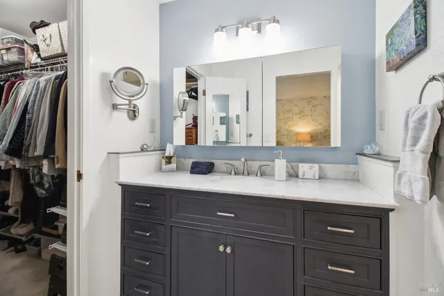 a bathroom with a granite countertop sink vanity and mirror