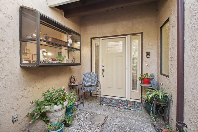 a backyard of a house with dining table and chairs