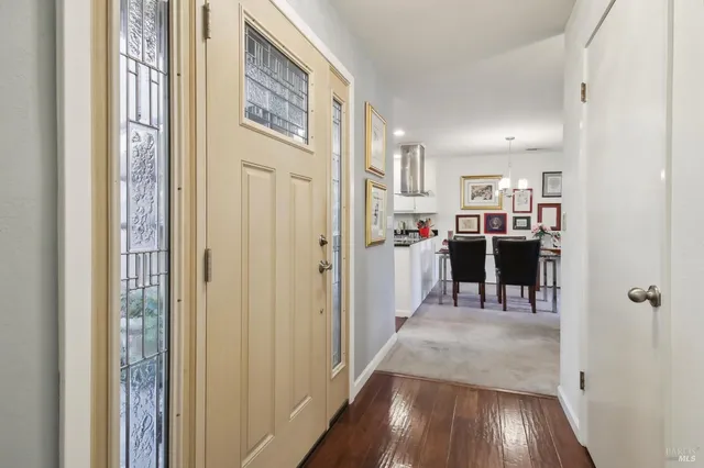 a view of a hallway with wooden floor and windows