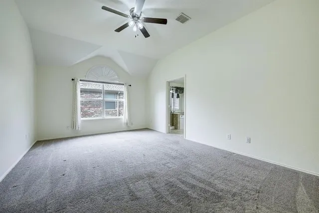 an empty room with windows and fan