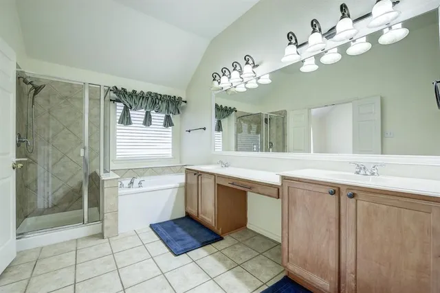 a spacious bathroom with a granite countertop sink a large mirror and a bathtub