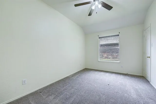 an empty room with a window and a ceiling fan
