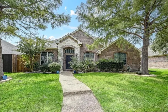 a front view of a house with yard and green space