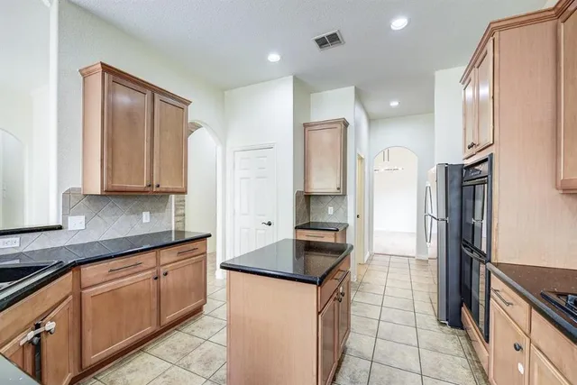 a kitchen with stainless steel appliances granite countertop a refrigerator and a sink