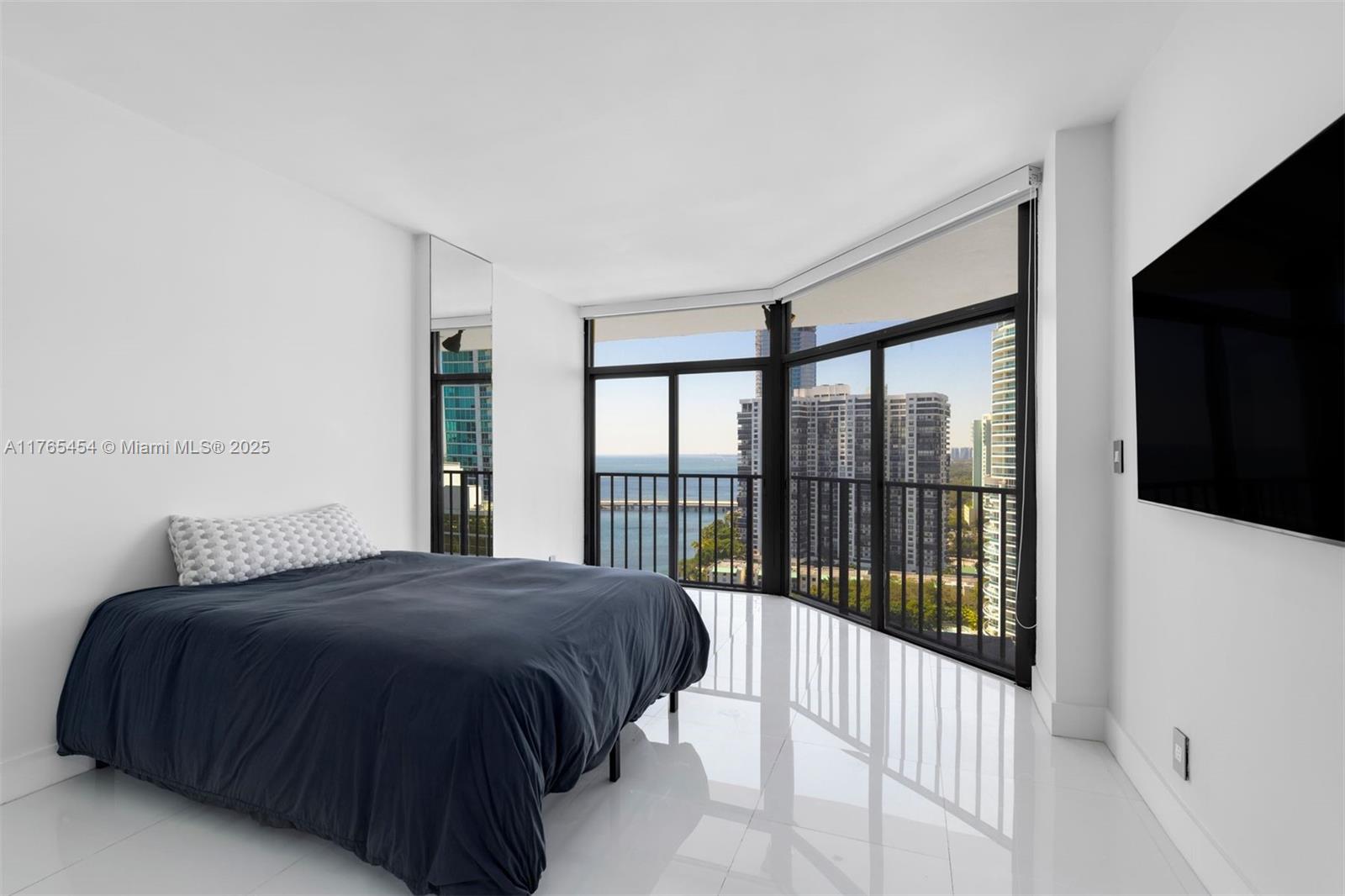 1925 Brickell Avenue, Unit DPH7 Miami, FL 33129 - Photo 38 of 45 a bedroom with a large bed and a flat tv screen next to a window