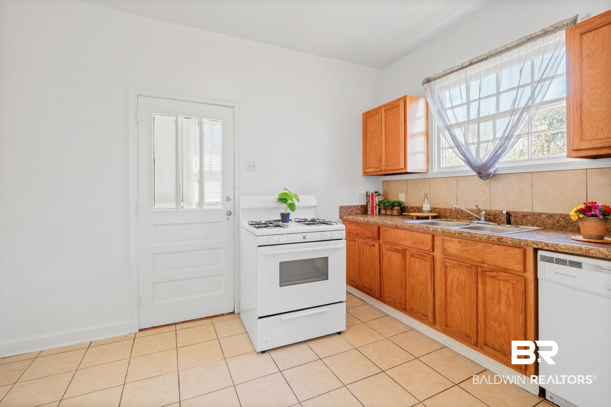 1707 Church Street Mobile, AL 36604 - Photo 20 of 43 Kitchen with decorative backsplash, white appliances, light tile patterned floors, and a sink