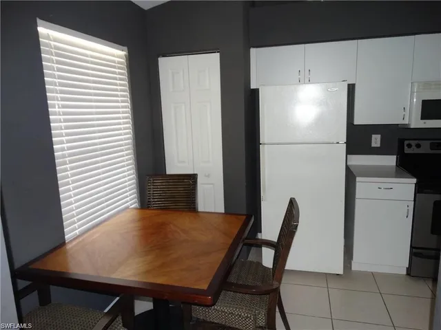 a kitchen with a table chairs and a refrigerator