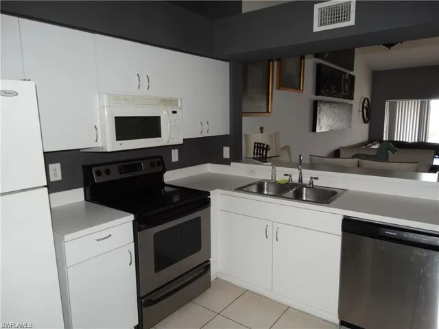 a kitchen with a sink and white cabinets