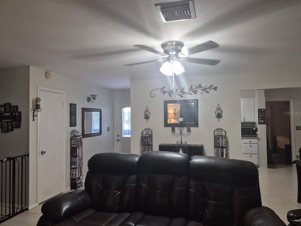 1107 Cable Lane Northeast Palm Bay, FL 32905 - Photo 15 of 17 a living room with furniture a chandelier and a flat screen tv