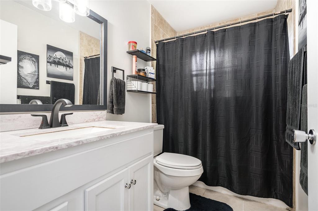 1107 Cable Lane Northeast Palm Bay, FL 32905 - Photo 4 of 17 a bathroom with a sink a toilet and shower