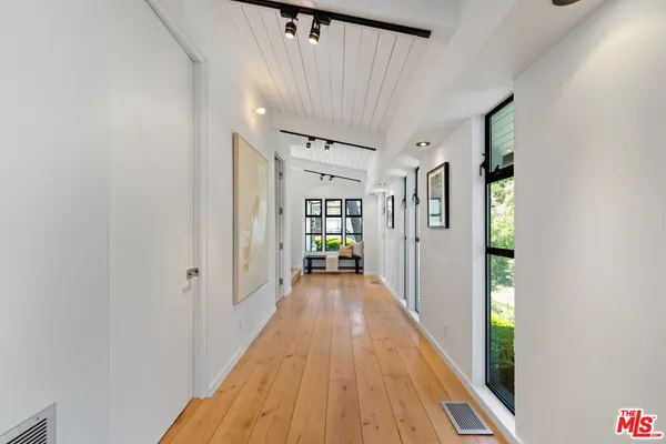 a view of a hallway with wooden floor and staircase