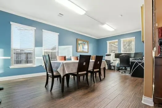 a view of a a dining room with furniture window and wooden floor