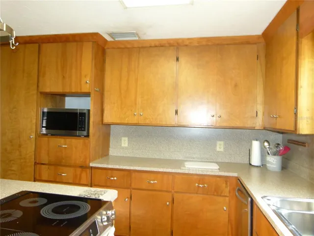 a kitchen with stainless steel appliances granite countertop a sink a refrigerator and a stove