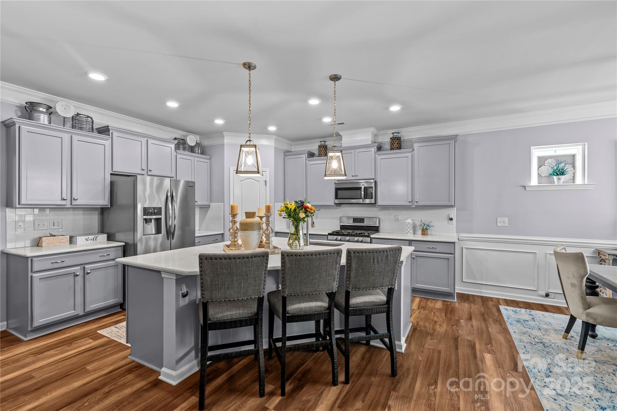 8097 Asher Chase Trail Lancaster, SC 29720 - Photo 5 of 47 a kitchen with kitchen island granite countertop a dining table chairs refrigerator and cabinets