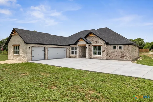 a front view of a house with a garden and yard