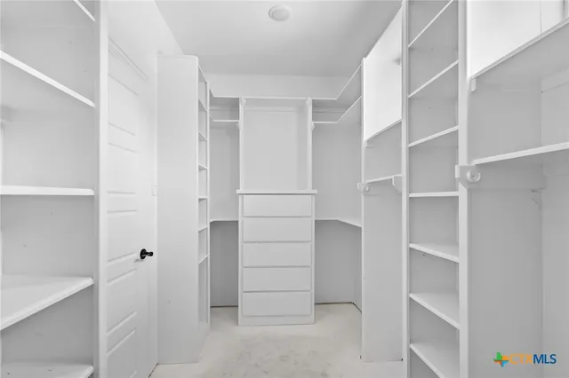 a view of walk in closet with empty racks