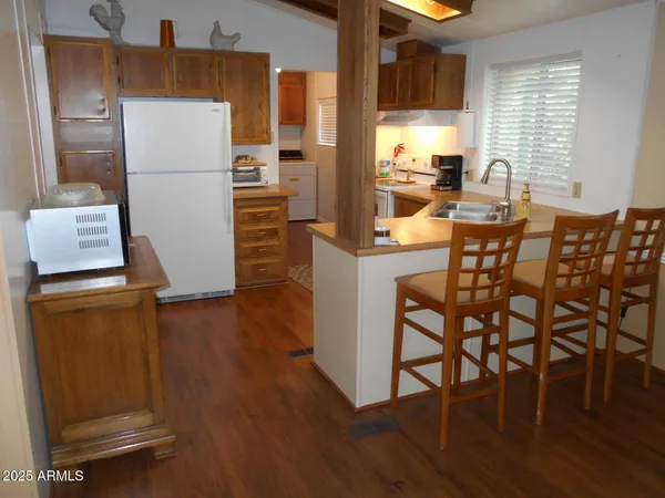 a kitchen with a table chairs refrigerator and microwave