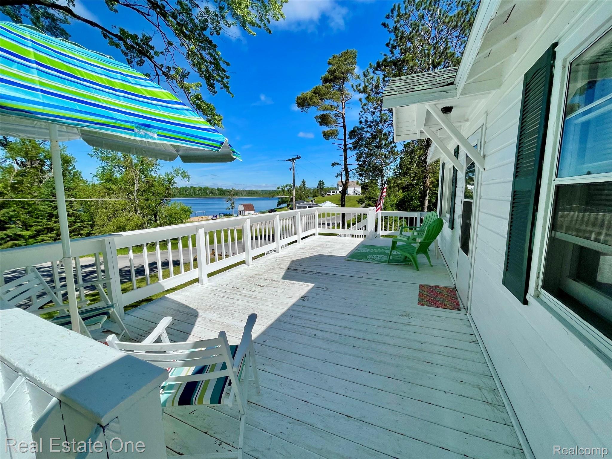 4160 Hawk Road Lincoln, MI 48742 - Photo 7 of 48 Expansive white-painted wood deck with a full railing, offering distant water and tree views