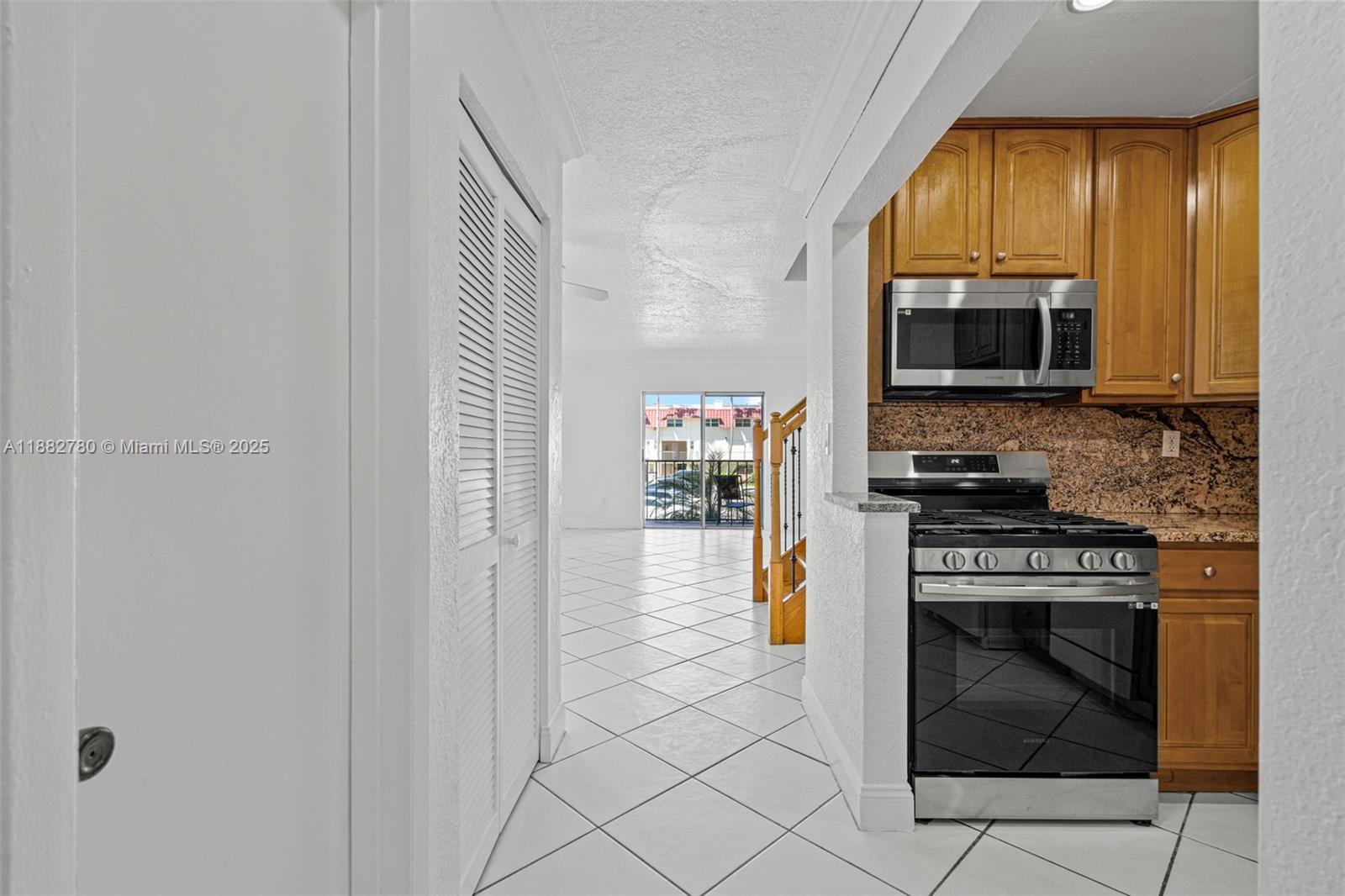8650 Southwest 67th Avenue, Unit 1027 Pinecrest, FL 33156 - Photo 2 of 41 a kitchen with a stove and a microwave