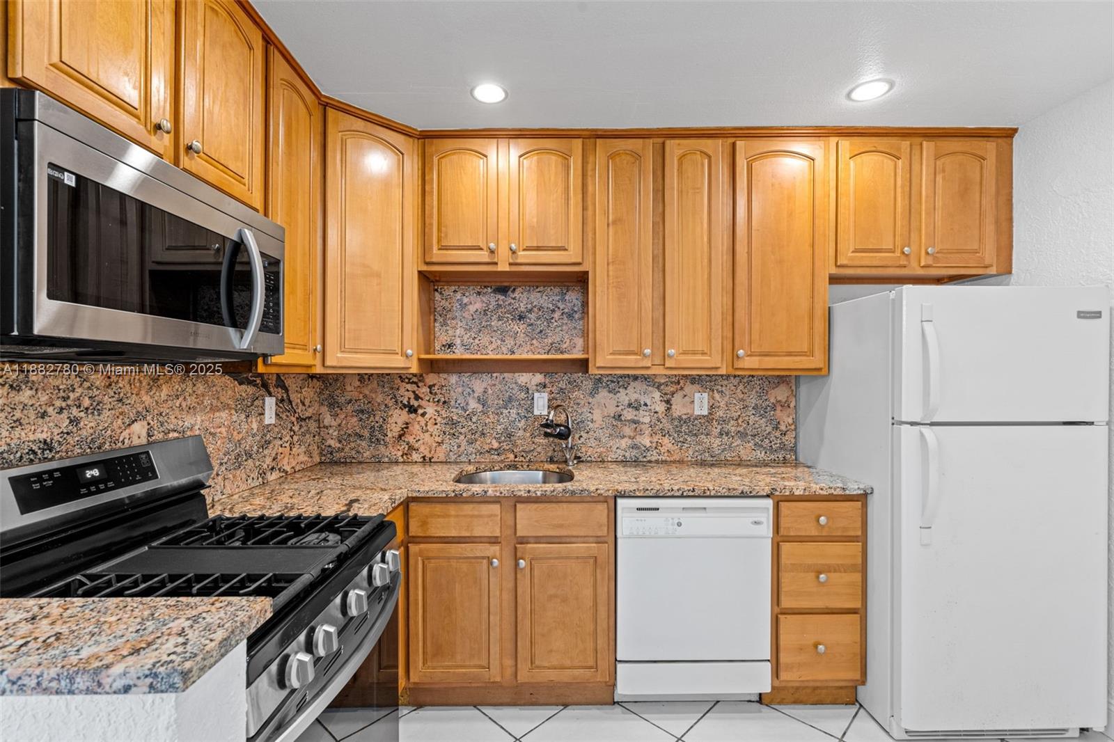 8650 Southwest 67th Avenue, Unit 1027 Pinecrest, FL 33156 - Photo 3 of 41 a kitchen with stainless steel appliances granite countertop a stove a sink and a microwave