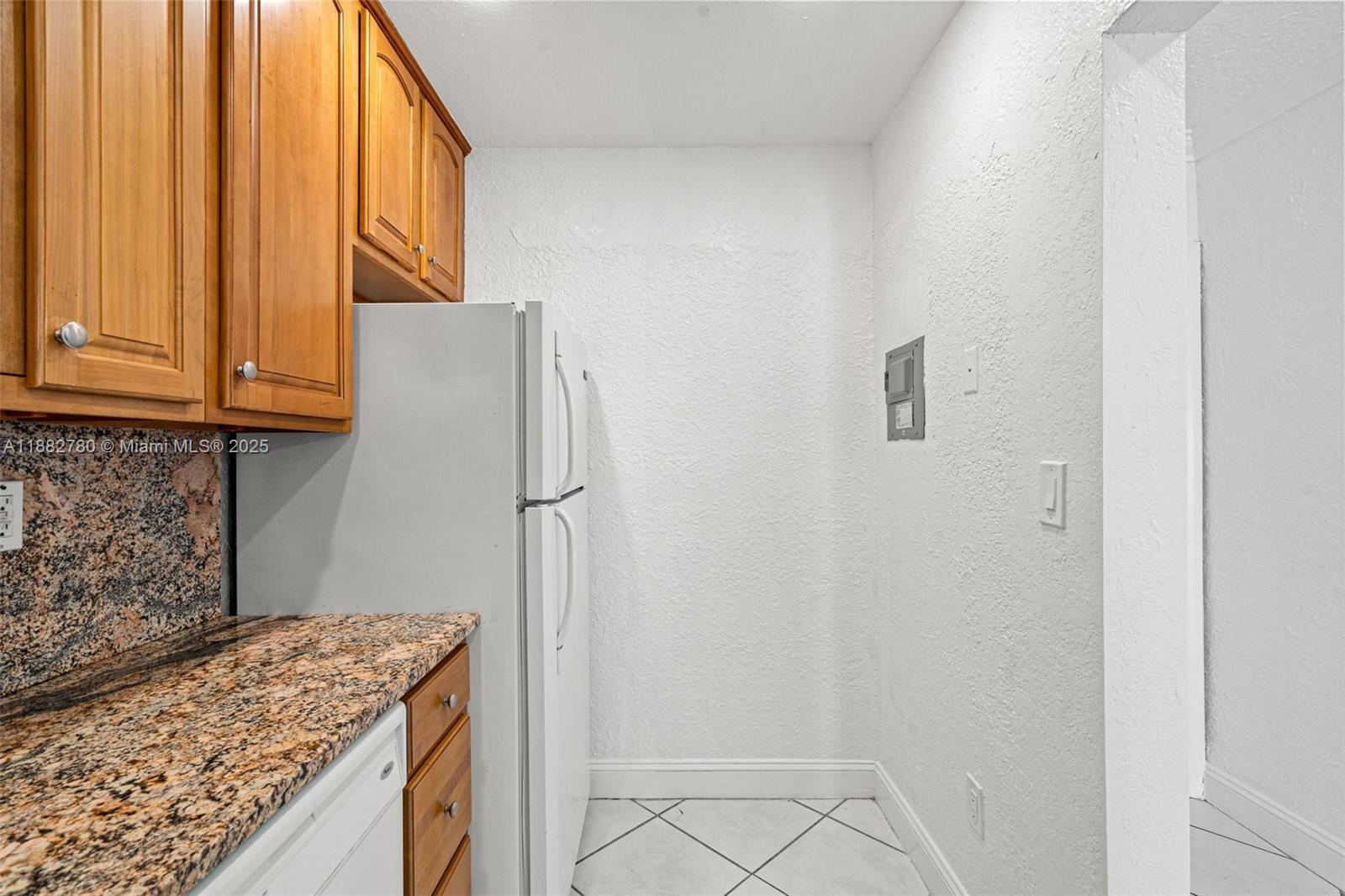 8650 Southwest 67th Avenue, Unit 1027 Pinecrest, FL 33156 - Photo 4 of 41 a kitchen with a refrigerator and cabinets