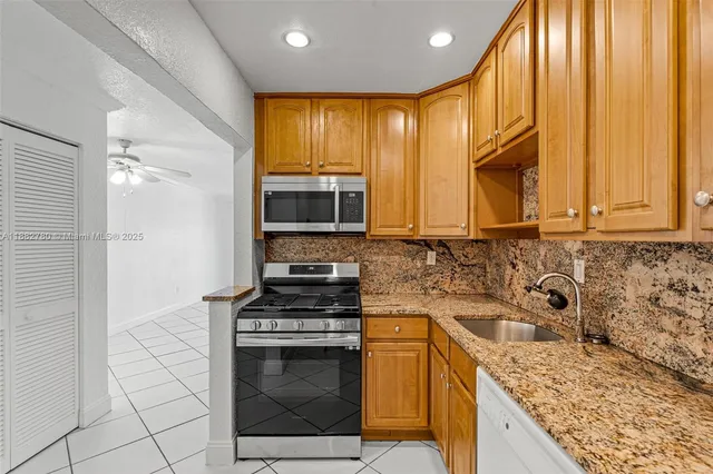 a kitchen with granite countertop cabinets stainless steel appliances a sink and counter space
