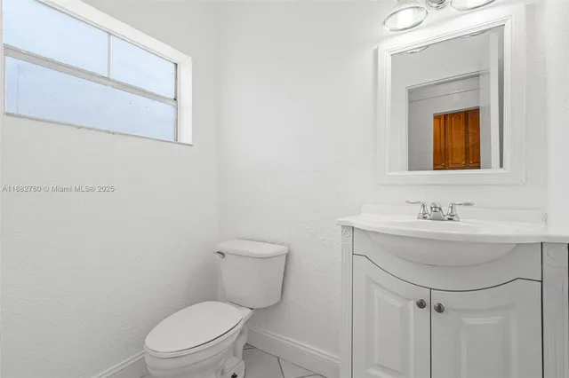a bathroom with a toilet a sink and mirror