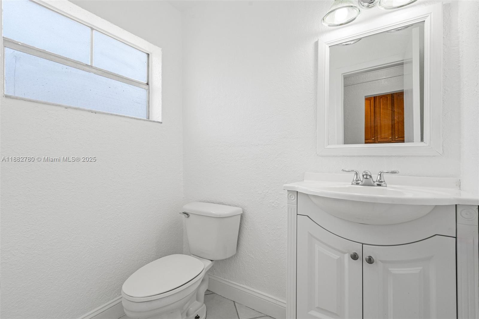 8650 Southwest 67th Avenue, Unit 1027 Pinecrest, FL 33156 - Photo 7 of 41 a bathroom with a toilet a sink and mirror