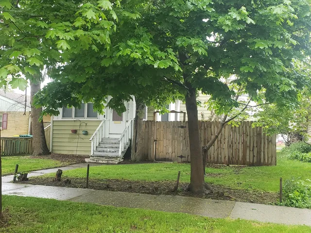 a view of a bench in a yard with wooden fence