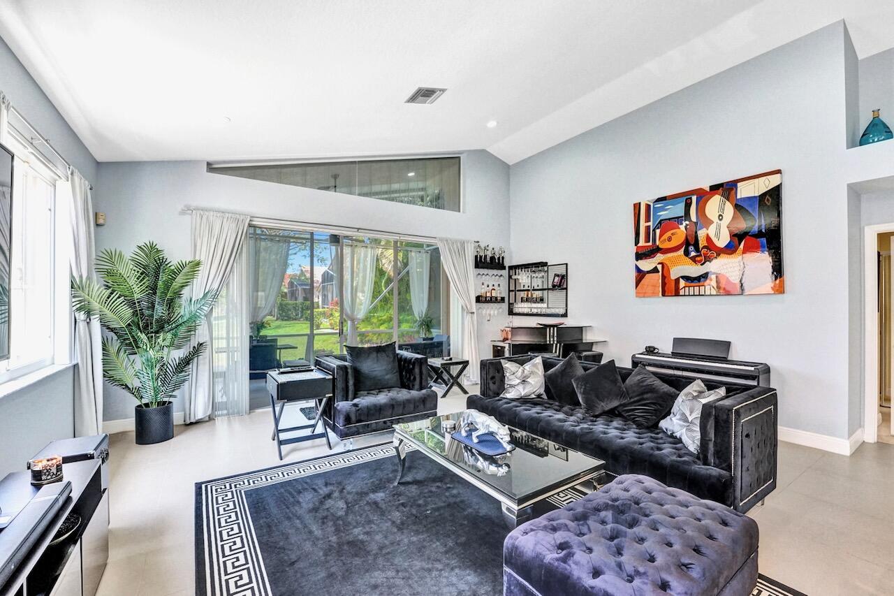 11067 Springbrook Circle Boynton Beach, FL 33437 - Photo 17 of 50 a living room with furniture a rug a large window and a potted plant