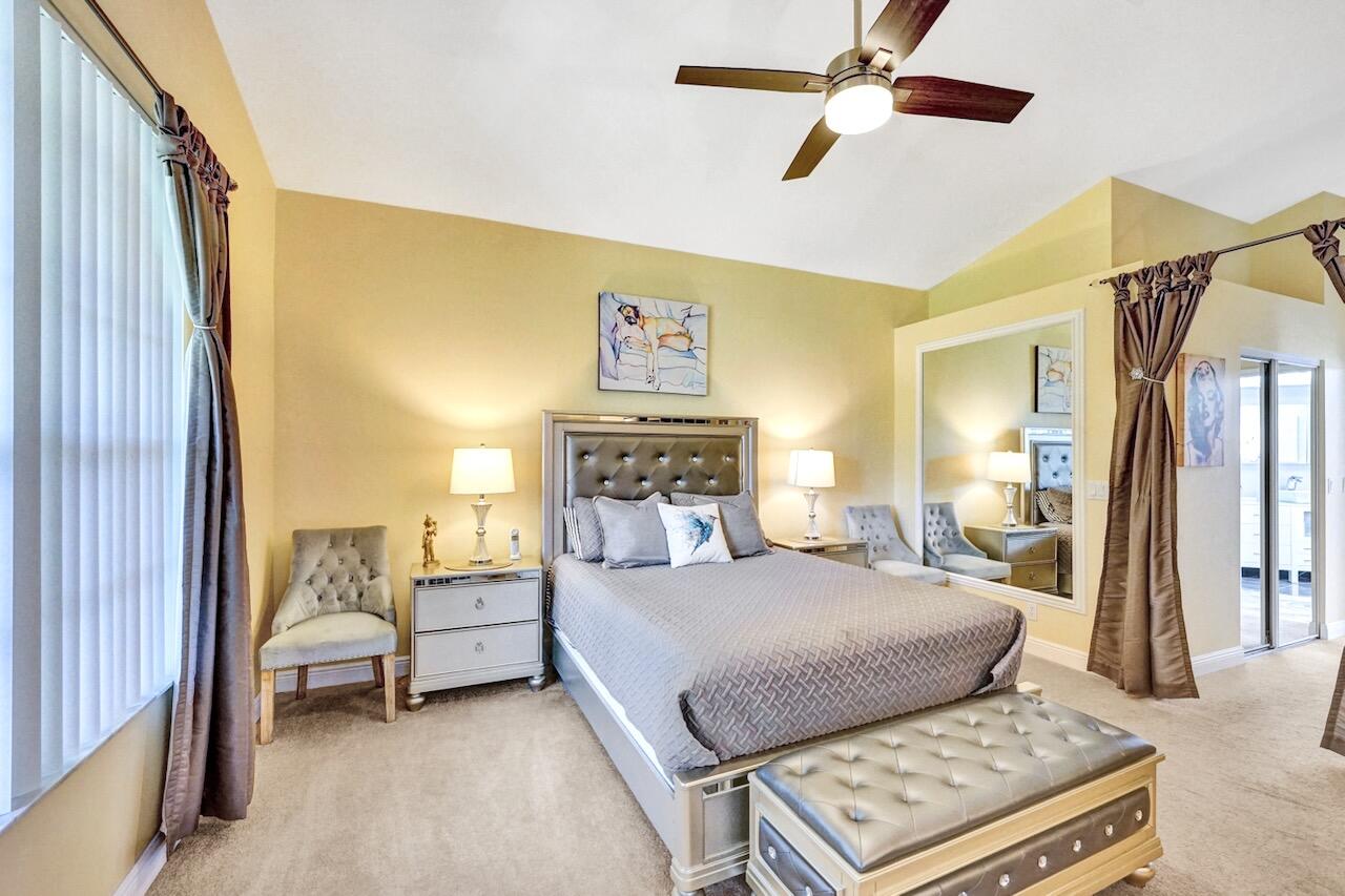 11067 Springbrook Circle Boynton Beach, FL 33437 - Photo 24 of 50 a bedroom with a bed and a chandelier