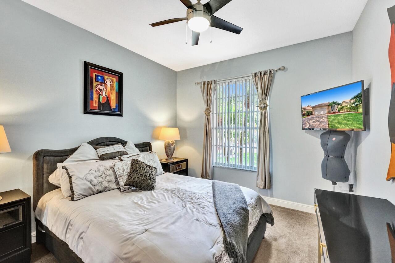 11067 Springbrook Circle Boynton Beach, FL 33437 - Photo 30 of 50 a bedroom with a bed and a chandelier