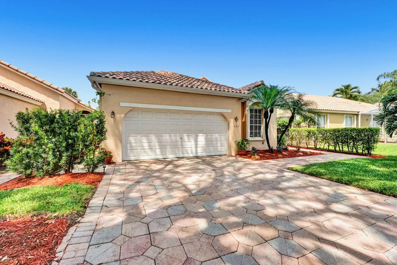 11067 Springbrook Circle Boynton Beach, FL 33437 - Photo 3 of 50 a front view of a house with a yard