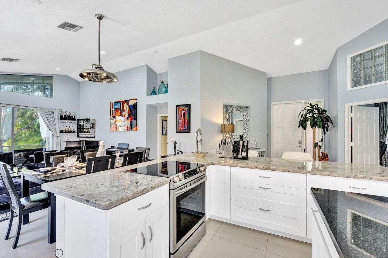 11067 Springbrook Circle Boynton Beach, FL 33437 - Photo 9 of 50 a kitchen with a stove a sink and a living room view