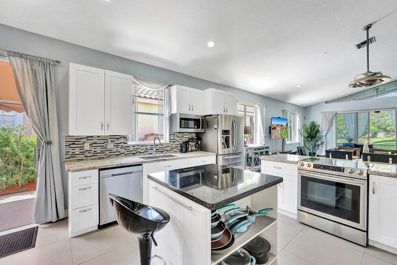 11067 Springbrook Circle Boynton Beach, FL 33437 - Photo 10 of 50 a kitchen with a stove a sink and a refrigerator