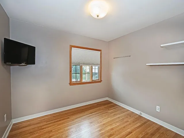 a view of a room with wooden floor and a window