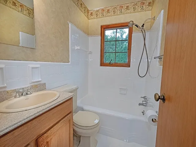 a bathroom with a granite countertop sink toilet and shower