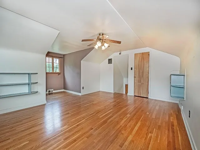 a view of a livingroom with wooden floor and a ceiling fan