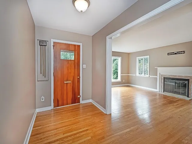 an empty room with wooden floor and fireplace