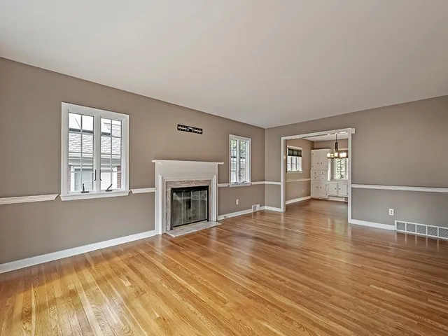a view of empty room with wooden floor and fireplace