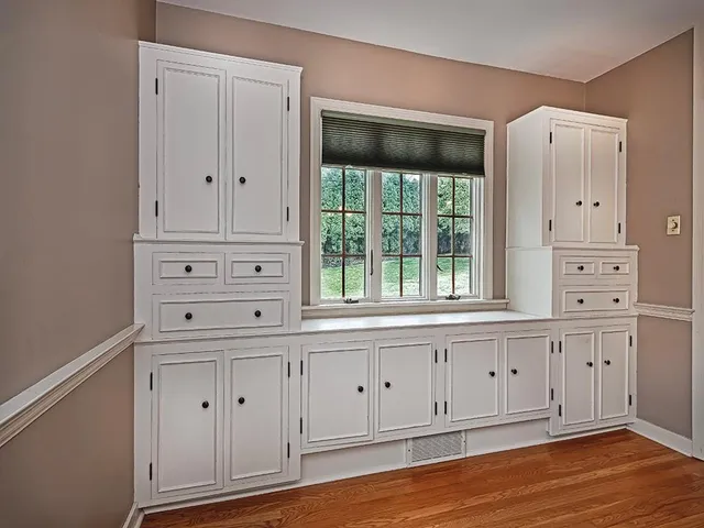 a view of white cabinets with wooden floor