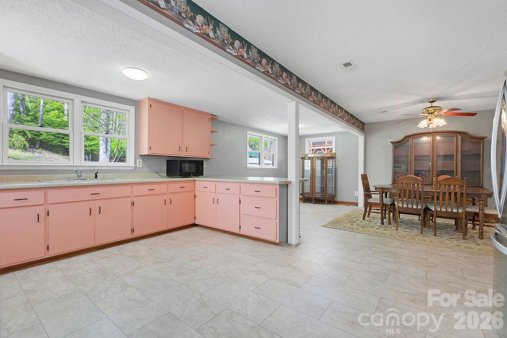 1482 Island Ford Road Brevard, NC 28712 - Photo 13 of 48 a large white kitchen with granite countertop a stove a sink a dining table and chairs