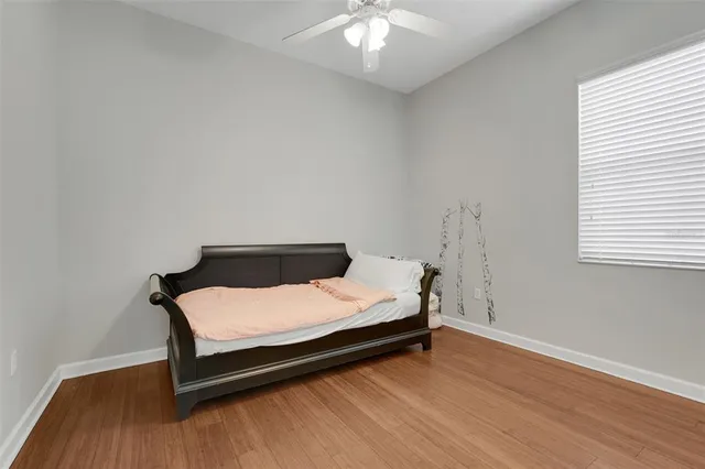 a bedroom with a bed and wooden floor