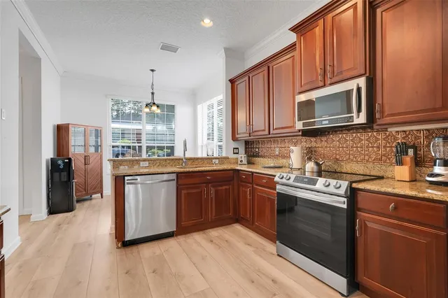 a kitchen with stainless steel appliances granite countertop a stove sink microwave and refrigerator